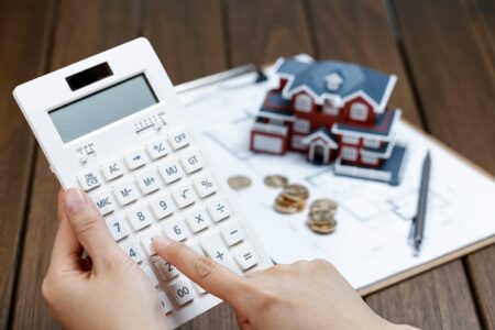 imagen de la mano de una mujer con una calculadora comprobando la subrogacion de su hipoteca